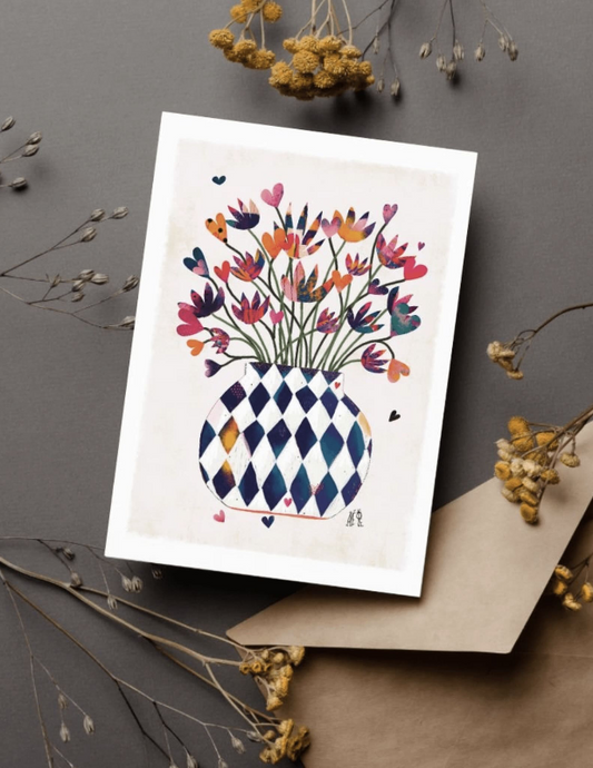 Carte postale avec un gros bouquet de fleurs de toutes les couleurs dans un gros vase rond quadrillé losange bleu et blanc