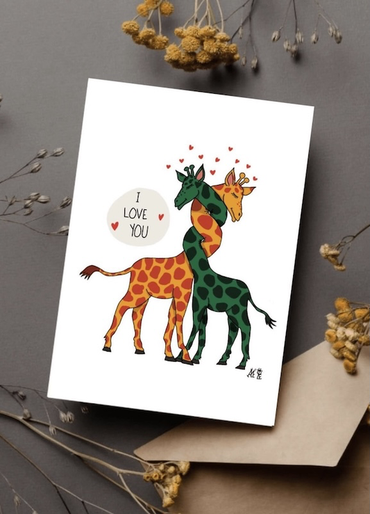 Deux girafes amoureuses une verte et l'autre jaune. Emmêlées par leur cou. Une bulle disant "i love you" sur le côté.