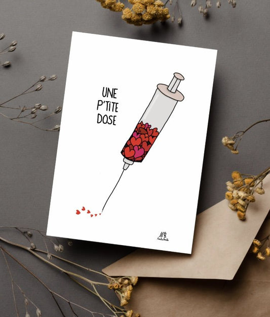 Carte postale représentant une seringue avec des coeurs dedans. il est écrit "une petite dose". Carte idéale pour un proche