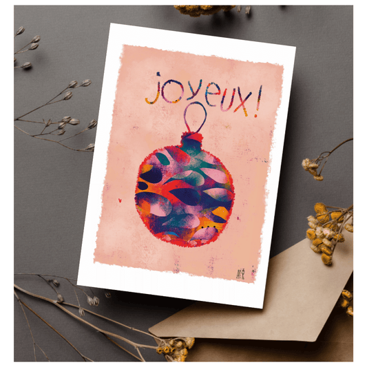 Carte postale avec une boule de noël multicolore sur fond saumon clair. Idéale pour souhaite un joyeux noël