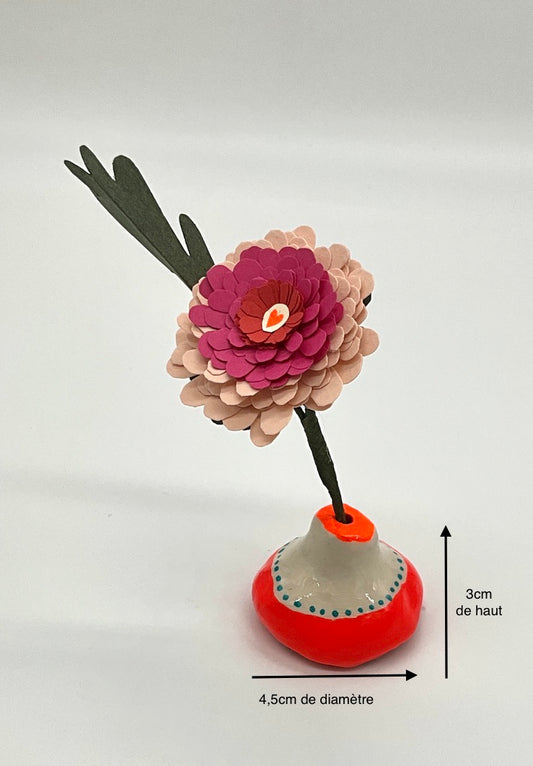 Petite fleur en forme de pâquerette réalisée avec du papier découpé. Sur un vase en argile, fluo. idée cadeau mignon