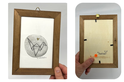 Gravure représentant un oiseau à la manière d'une grue en origami. Un coeur en feuille d'or est au-dessus. 